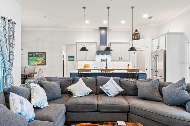 living area with recessed lighting, a towering ceiling, visible vents, and crown molding