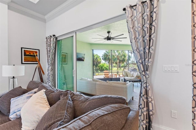 living area featuring ornamental molding, baseboards, and a ceiling fan