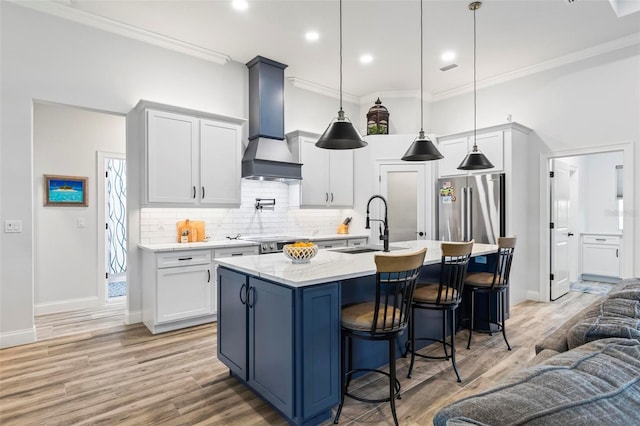 kitchen featuring premium range hood, high end refrigerator, ornamental molding, and a breakfast bar