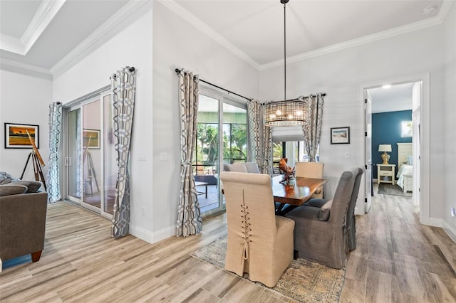 dining space featuring light wood-type flooring, crown molding, and baseboards