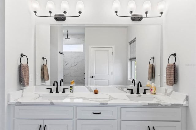 full bathroom featuring a sink, double vanity, and a tile shower