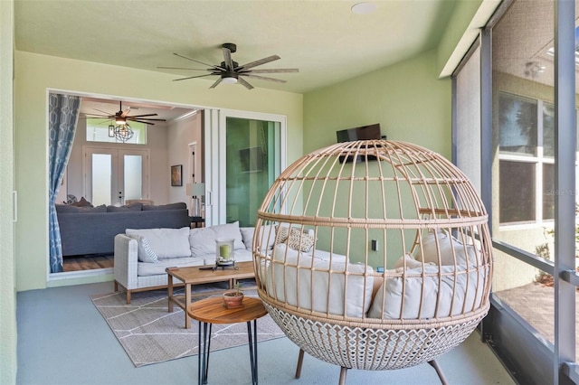 sunroom featuring french doors and a ceiling fan