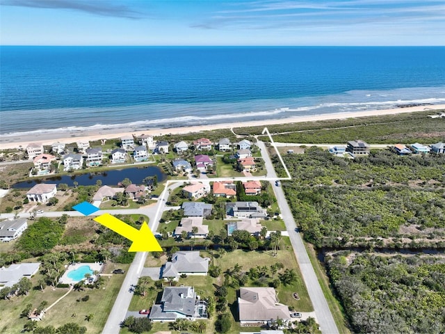 drone / aerial view with a beach view, a water view, and a residential view