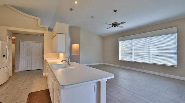 kitchen featuring white cabinetry, light hardwood / wood-style flooring, sink, vaulted ceiling, and ceiling fan