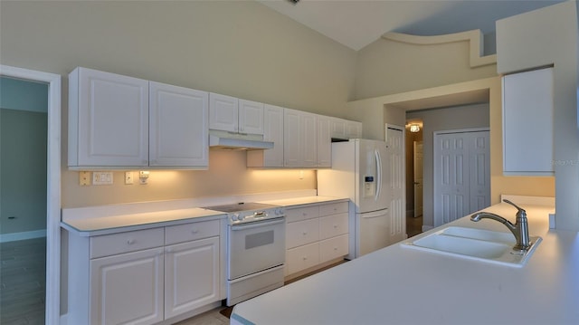 kitchen with white cabinetry, lofted ceiling, sink, white appliances, and hardwood / wood-style floors