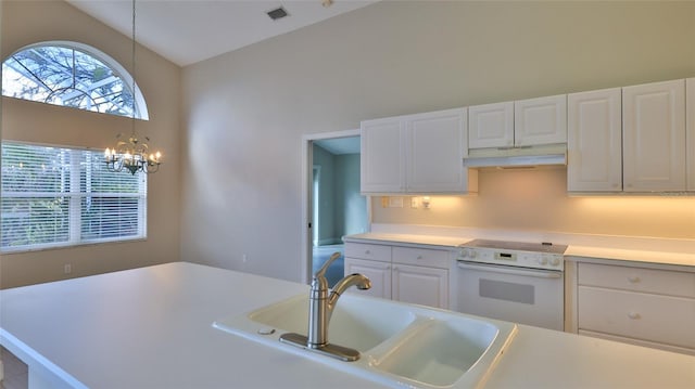 kitchen with hanging light fixtures, white electric range, sink, white cabinets, and a chandelier