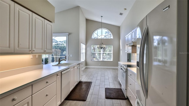 kitchen featuring white cabinetry, decorative light fixtures, sink, white appliances, and high vaulted ceiling