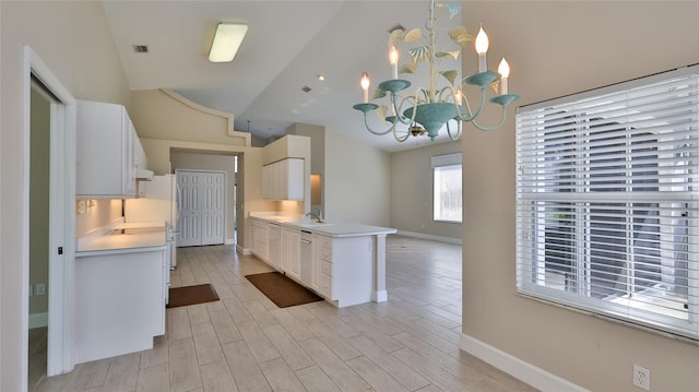 kitchen with a notable chandelier, light hardwood / wood-style floors, white cabinetry, and pendant lighting