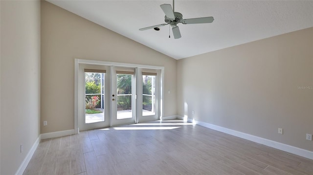 empty room with ceiling fan, french doors, lofted ceiling, and light hardwood / wood-style floors