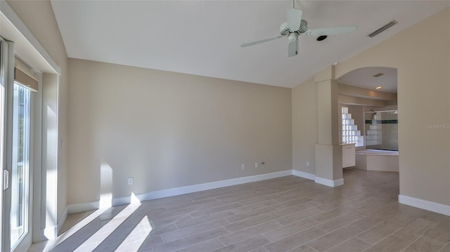 spare room with light wood-type flooring, vaulted ceiling, and ceiling fan