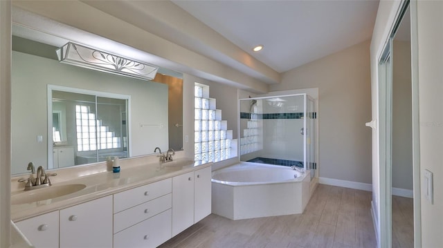 bathroom featuring plenty of natural light, vanity, independent shower and bath, and vaulted ceiling