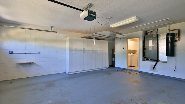 garage with heating unit, water heater, separate washer and dryer, and a garage door opener