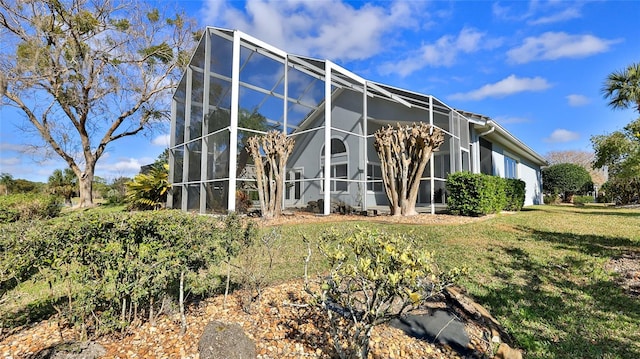 view of property exterior with a yard and glass enclosure