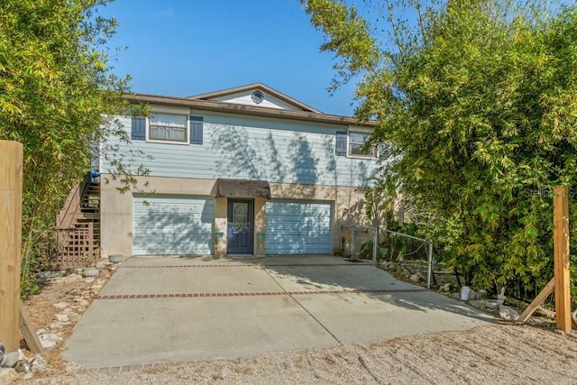 view of front of home with stucco siding, driveway, an attached garage, and stairs