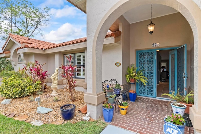 entrance to property featuring a tile roof and stucco siding