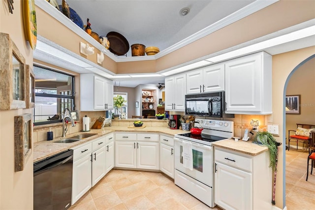 kitchen featuring light countertops, white cabinets, a sink, and black appliances