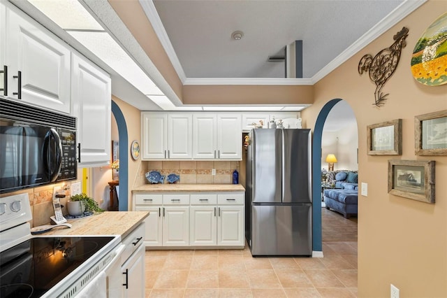 kitchen with black microwave, white electric range, white cabinets, light countertops, and freestanding refrigerator