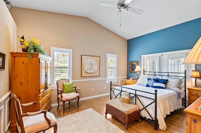 bedroom with ceiling fan, baseboards, vaulted ceiling, and wood finished floors