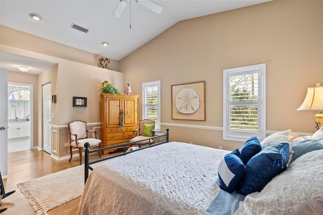 bedroom featuring light wood-style floors, lofted ceiling, multiple windows, and visible vents