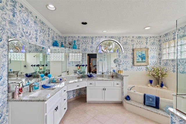 full bath with a sink, a textured ceiling, a bath, and wallpapered walls