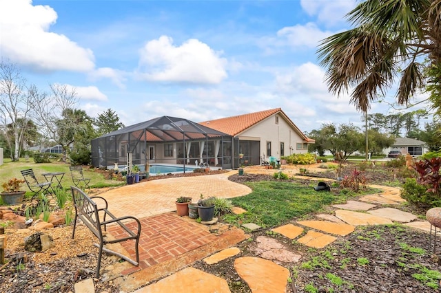 rear view of property with a lanai, an outdoor pool, and a patio