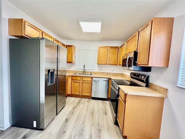 kitchen featuring light hardwood / wood-style flooring, stainless steel appliances, and sink