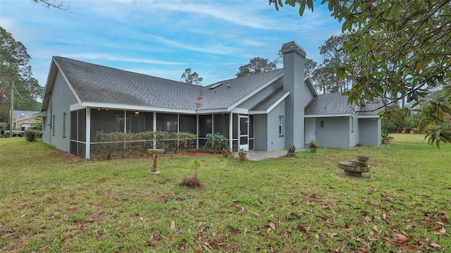 back of property featuring a lawn and a sunroom