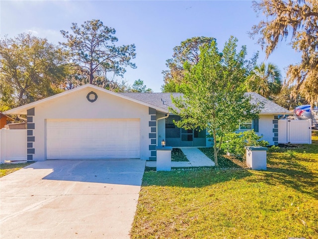 ranch-style home with stucco siding, fence, concrete driveway, a front yard, and a garage