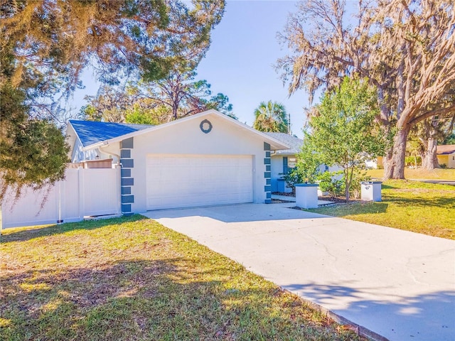 ranch-style home with an attached garage, fence, concrete driveway, stucco siding, and a front lawn