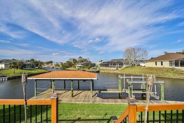 dock area with a residential view, a water view, a yard, and boat lift