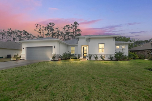 view of front facade with a garage, concrete driveway, a front lawn, and stucco siding