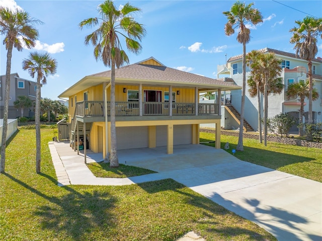 coastal inspired home featuring driveway, a front yard, board and batten siding, and an attached garage