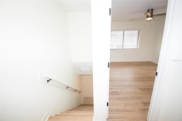 stairs with ceiling fan and hardwood / wood-style floors