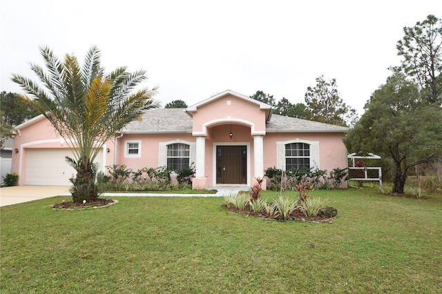 view of front of home with a garage, driveway, a front yard, and stucco siding