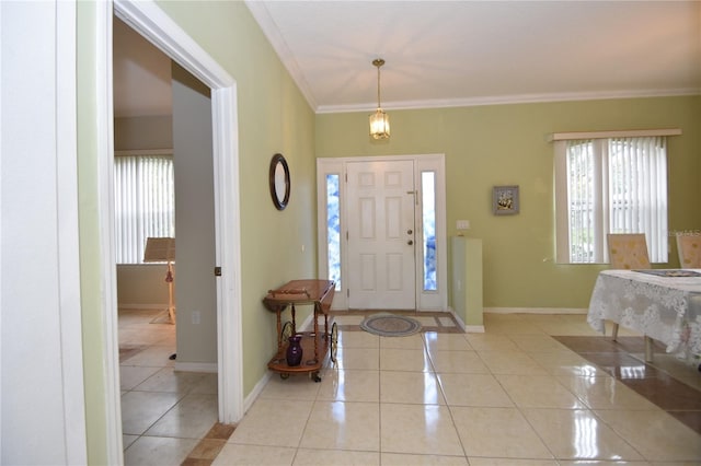 entryway with light tile patterned floors, ornamental molding, and baseboards