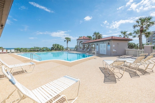 pool with a patio and fence