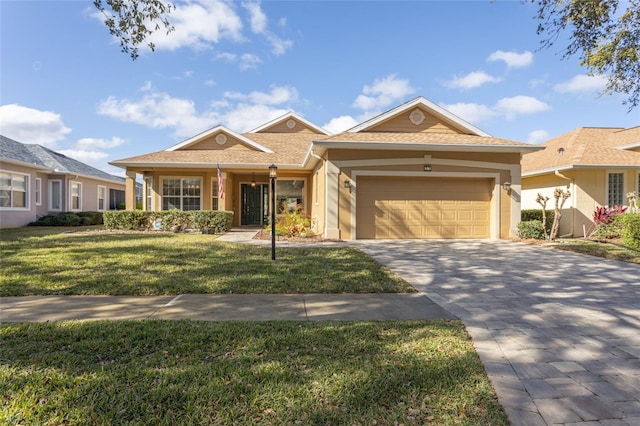 view of front facade with a garage, stucco siding, decorative driveway, and a front yard