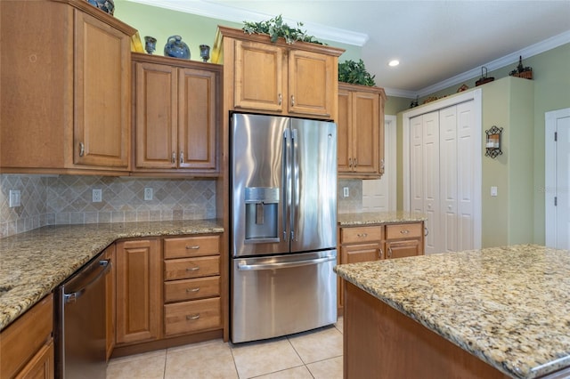 kitchen featuring light stone countertops, light tile patterned floors, appliances with stainless steel finishes, and ornamental molding