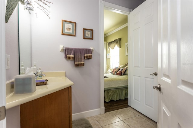 ensuite bathroom with crown molding, vanity, ensuite bath, tile patterned flooring, and baseboards