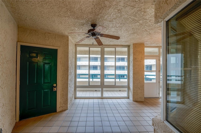 interior space with a ceiling fan, a healthy amount of sunlight, and light tile patterned flooring