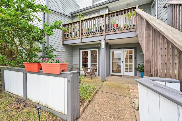 back of house with french doors and a balcony