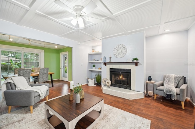 living room with a tile fireplace, coffered ceiling, hardwood / wood-style flooring, and ceiling fan