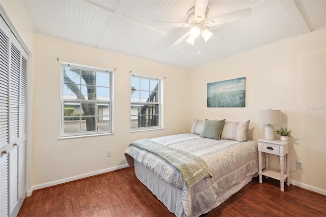 bedroom featuring dark wood-type flooring, ceiling fan, and a closet