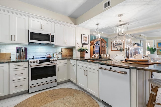 200 Ocean Crest Dr Unit 306, Palm Coast, FL 32137 - kitchen with a peninsula, white appliances, a sink, white cabinets, and decorative light fixtures