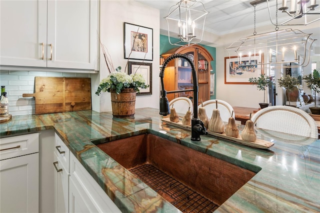 200 Ocean Crest Dr Unit 306, Palm Coast, FL 32137 - details featuring an inviting chandelier, a sink, white cabinetry, and decorative light fixtures