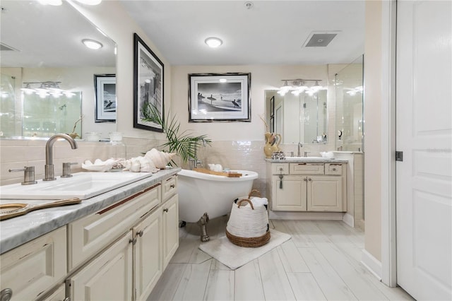 200 Ocean Crest Dr Unit 306, Palm Coast, FL 32137 - bathroom featuring a freestanding bath, two vanities, a sink, and tile walls