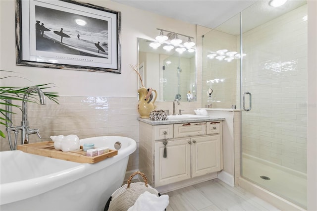 200 Ocean Crest Dr Unit 306, Palm Coast, FL 32137 - bathroom featuring a freestanding bath, a shower stall, vanity, and tile walls