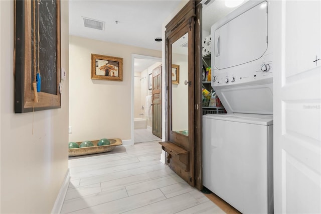 200 Ocean Crest Dr Unit 306, Palm Coast, FL 32137 - laundry area with light wood finished floors, visible vents, stacked washing maching and dryer, laundry area, and baseboards
