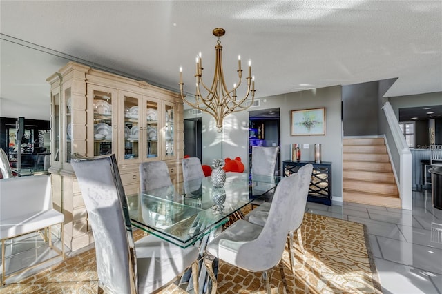 dining space featuring a textured ceiling, stairway, and an inviting chandelier