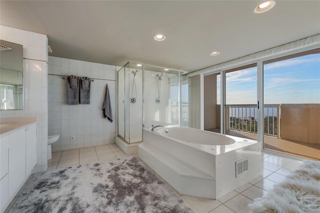 full bath featuring tile walls, toilet, vanity, tile patterned flooring, and a bath